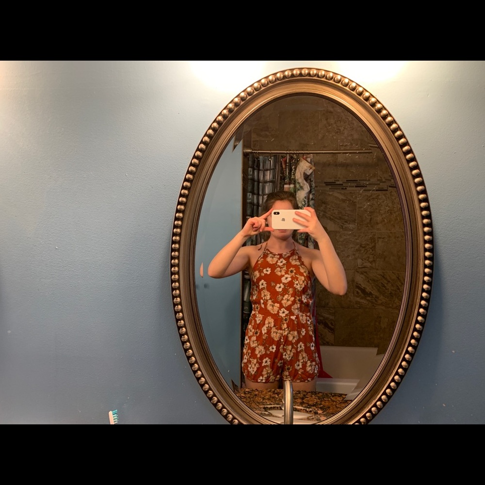 Open back romper, orange/rust color with flowers.